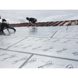 Deux ouvriers posent une couche de fixation ou d’isolation sur un toit et installent des panneaux sous une bâche, avec un ciel nuageux. meilleur isolant pour toiture